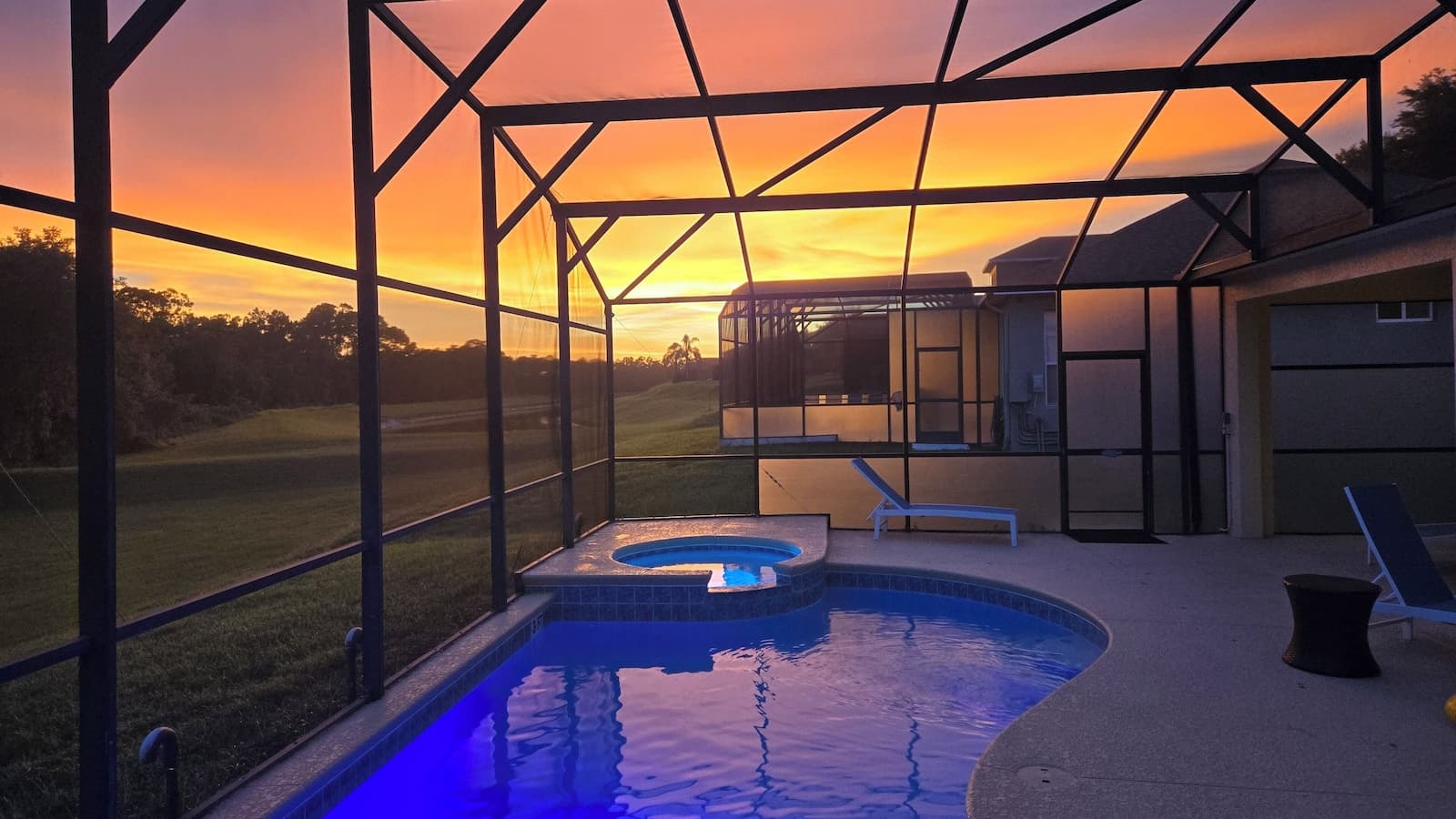 Private screened pool and spa at Islands of Magic Orlando, lit up at sunset